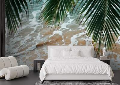 The coconut tree leaves with background with sea waves on the beach for mockup background. Tropical sea beach template and palm leaf on seaside Wall mural