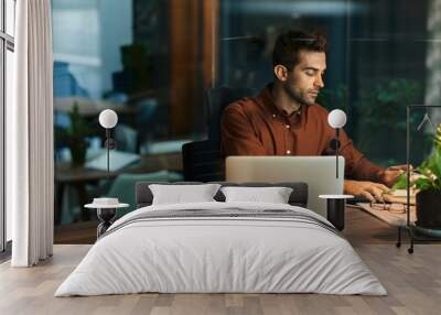 Businessman working alone in an office at night Wall mural