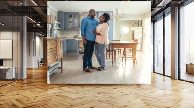 Content African couple standing together in their kitchen Wall mural