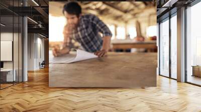 Craftsman leaning on a workshop bench reading furniture plans Wall mural