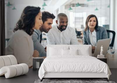 Diverse businesspeople smiling while working together on a laptop Wall mural