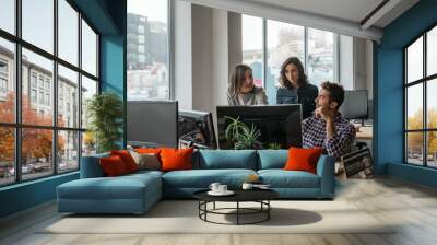 Diverse group of young designers working on a computer together Wall mural