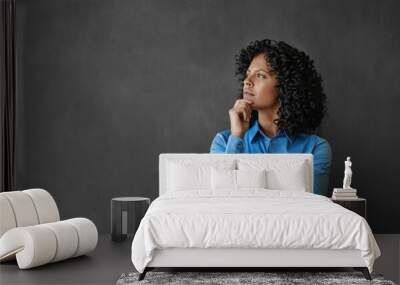 Entrepreneur standing by a chalkboard and thinking about her business Wall mural