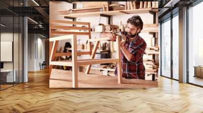 Furniture designer sanding a wooden chair frame Wall mural