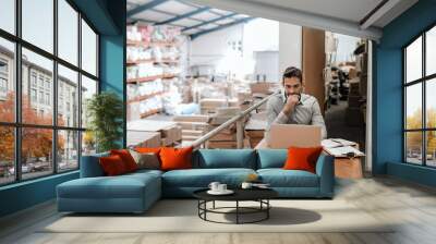 manager working online while sitting in a warehouse office Wall mural