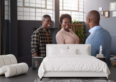 Smiling African coworkers shaking hands together in a modern office Wall mural