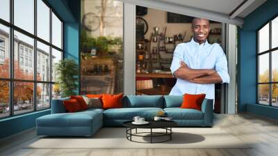 Smiling African entrepreneur standing at the door of his cafe Wall mural