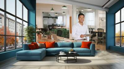 smiling asian businessman using a tablet in an office Wall mural