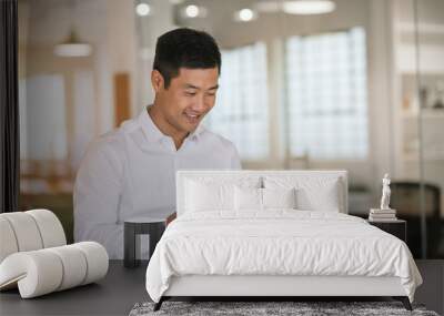 smiling asian businessman working with a tablet at work Wall mural