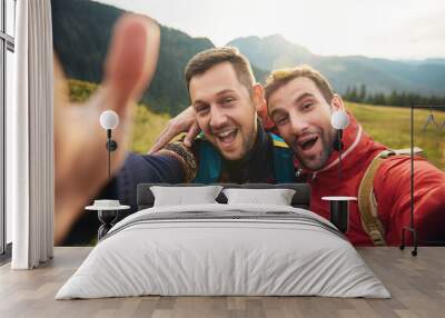 Smiling hikers taking a selfie while trekking in the wilderness Wall mural