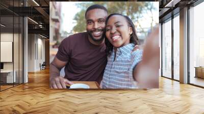 Smiling young African couple taking selfies together at a cafe Wall mural