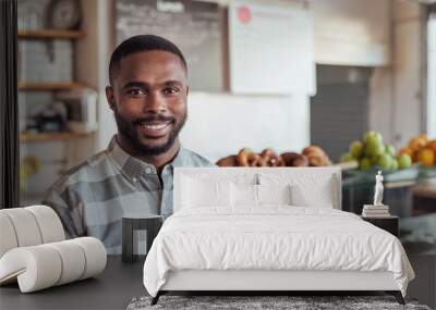 Smiling young African entrepreneur standing in his cafe Wall mural