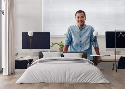 Smiling young Asian designer standing in a modern office Wall mural