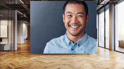 Smiling young Asian designer standing in an office Wall mural