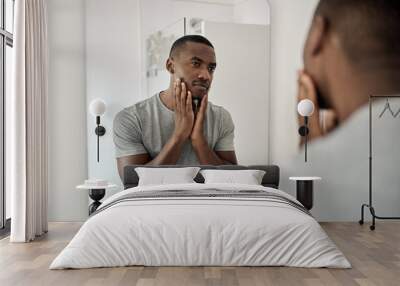 Young African American man touching his face in his bathroom Wall mural