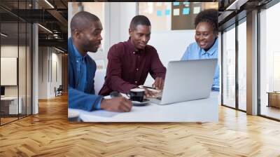 Young African colleagues working on a laptop in an office Wall mural