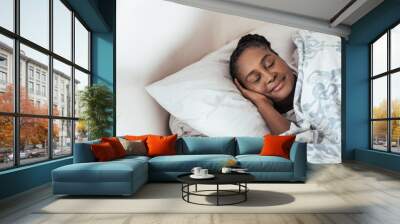 Young African woman fast asleep in her bed at home Wall mural