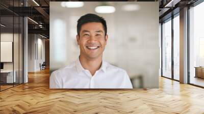 Young Asian businessman standing in an office smiling confidently Wall mural