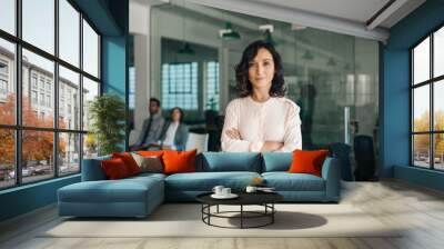 Young businesswoman standing confidently in a large modern office Wall mural