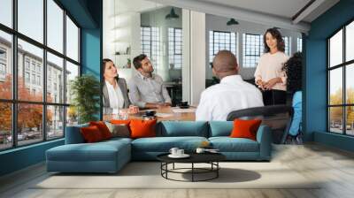 Young businesswoman talking with her team in an office Wall mural