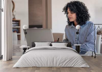 Young female entrepreneur working at home on her laptop Wall mural