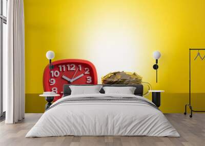 Clock and coins with yellow background Wall mural