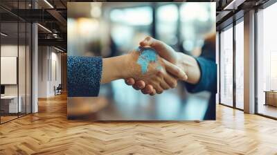 Close-up of handshake with a digital globe overlay symbolizing global business partnership. Wall mural