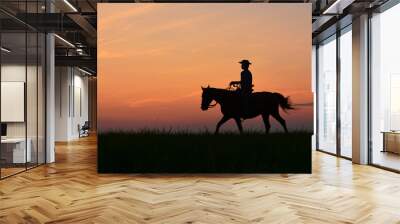 Cowboy in hat riding horse on colorful cloudy sky at sunset. Silhouette of  cowboy travel in wild west mountain like western film background Wall mural