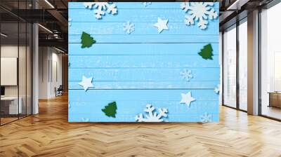 Holiday postcard frame. Christmas wooden decorations of snowflakes, white stars and green Xmas trees on a background of blue vintage old wooden boards. Background for your text and design Wall mural