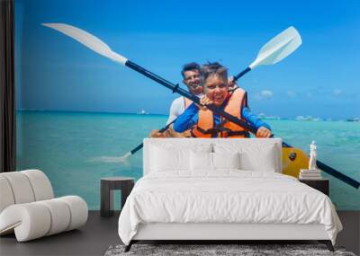 Father and son kayaking at tropical ocean Wall mural