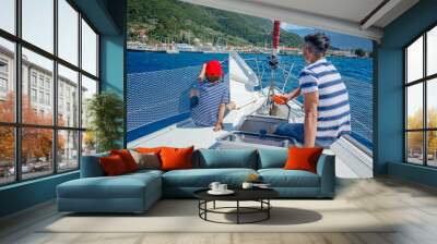 Father with adorable son resting on yacht Wall mural