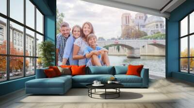 Happy family having fun near Notre-Dame cathedral in Paris. Tourists enjoying their vacation in France. Wall mural