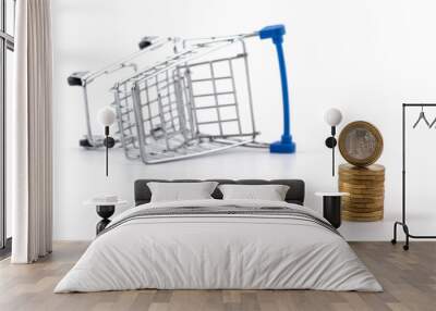 1 euro coins and an overturned shopping trolley from a supermarket on a white background Wall mural