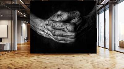 Black and White photo of senior woman hands praying on black background Wall mural