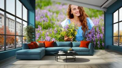 Beautiful woman in the blooming  field. Nature, vacation, relax and lifestyle. Summer landscape. Wall mural