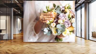 Engagement ring on the bride's finger. Wedding and marriage concept. Beautiful bride in a white dress with an elegant wedding ring on her finger. Bride's hands with a nice manicure. Wall mural