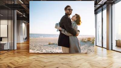 Fashion couple enjoying each other on beach during autumn sunny day. Travel, weekend, relax .and lifestyle concept.  Wall mural