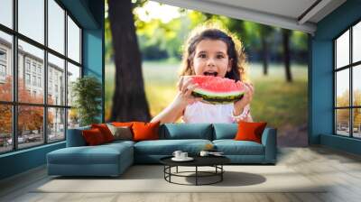 Funny kid eating watermelon outdoors in summer park, focus on eyes. Child, baby, healthy food. Youth lifestyle. Happiness, joy, holiday, beach, summer concept.

 Wall mural