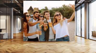 Group of people doing selfie with phone at the beach. Young friends enjoy summer party together. People, lifestyle, travel, nature and vacations concept. Wall mural