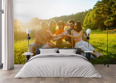 Group of young people having fun while drinking beer at picnic party. Friends enjoy sunny day. Vacation, weekend, friendship or holliday concept. Wall mural