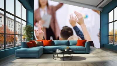 Group of young people sitting at a conference together raised hands to express their views. Business group meeting seminar training concept. Planning, analysis, collaborate work in teamwork. Wall mural