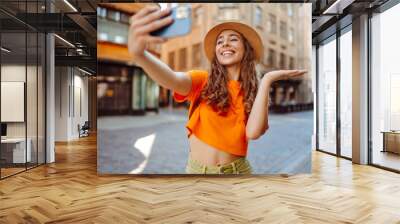 Selfie time. A tourist walks the streets and  takes selfie using smartphone camera.   Lifestyle, travel, tourism, active life. Wall mural