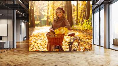 Stylish woman with a bicycle enjoying autumn weather in the park. Beautiful Woman walking  in the autumn forest. Wall mural