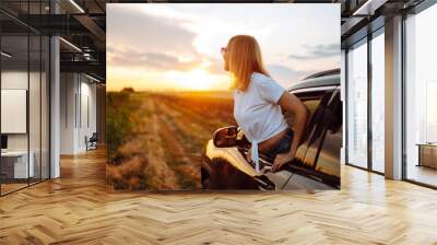 Towards adventure! Young woman is resting and enjoying the trip in the car. Lifestyle, travel, tourism, nature, active life. Wall mural