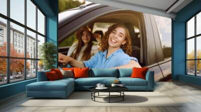 Two young women on car trip having fun. Lifestyle, travel, tourism, nature, active life. Wall mural