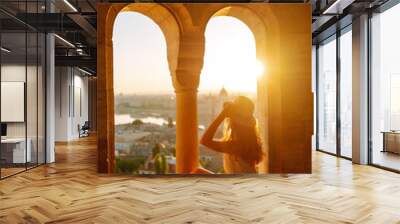 Young female tourist looking at panoramic view of the city at sunset.  Lifestyle, travel, tourism, nature, active life. Wall mural