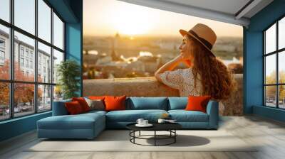 Young female tourist  looking at panoramic view of  the city at sunset. Lifestyle, travel, tourism, nature, active life. Wall mural