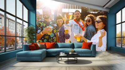 Young happy friends drinking beer and having fun at music festival together. Beach party, summer holiday, vacation concept. Friendship and celebration concept. Wall mural