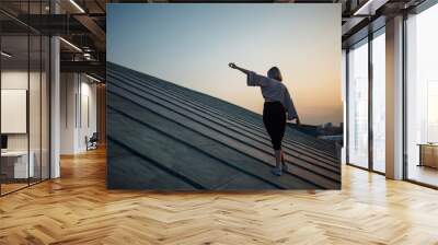 Young woman posing in the roof at sunset, freedom city atmosphere. People, lifestyle, relaxation concept. Wall mural