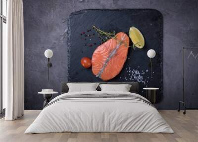 Raw salmon steak with spices on black stone board, top view Wall mural